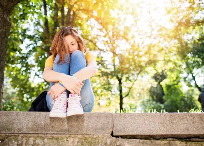 Teenage girl feeling depressed in the park