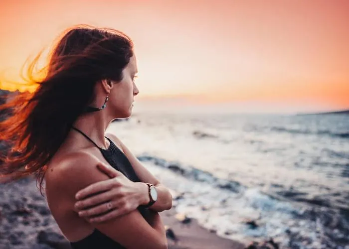 Girl in melancholy mood standing at the beach