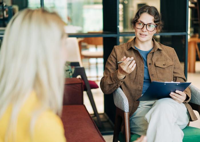 A female psychologist advises a client. Portrait of a professional modern woman. HR hires and conducts interviews.